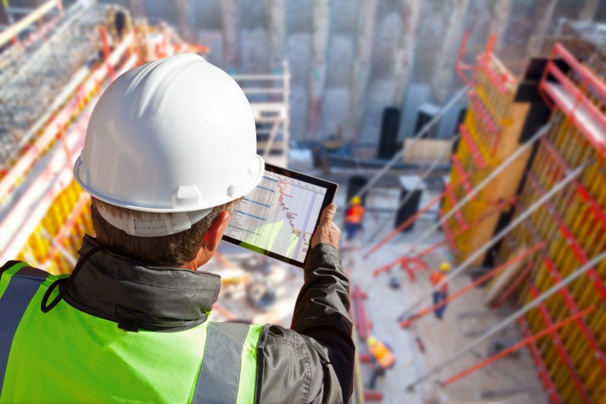 Quality manager adding data to a tablet on a construction work site