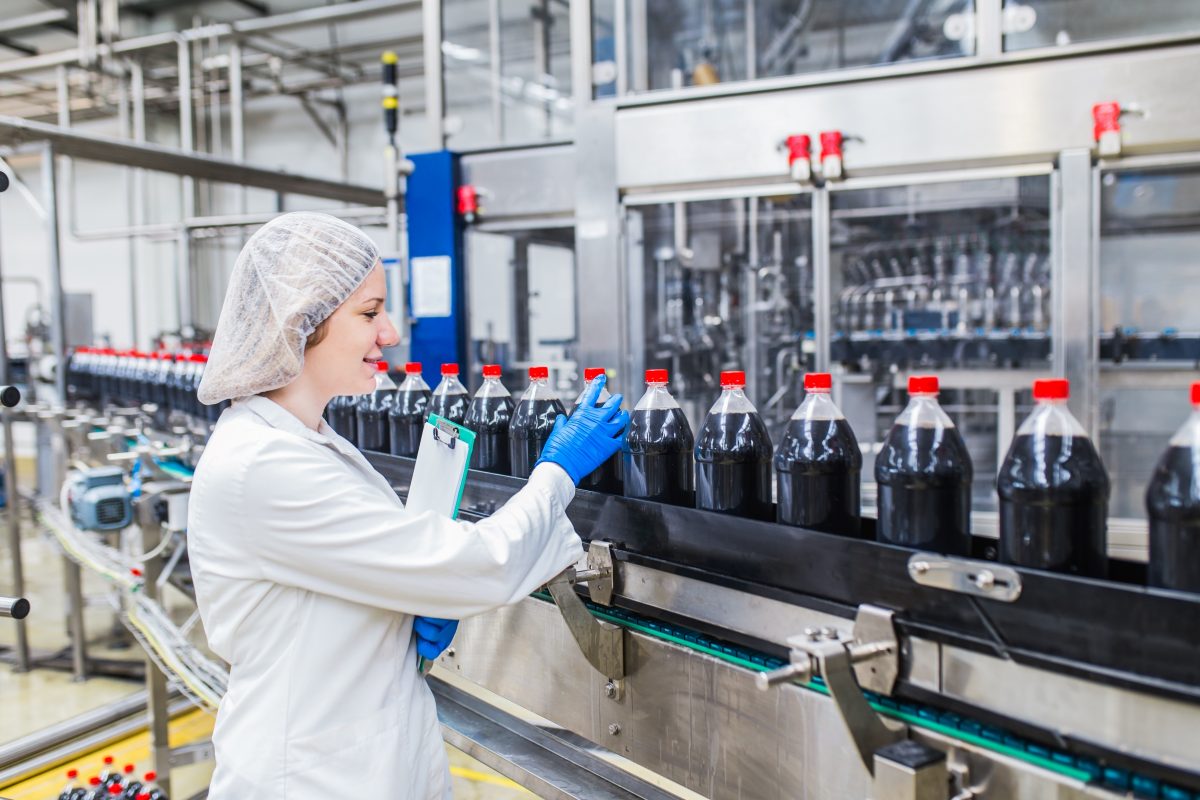 Quality manager inspects bottle seals during an ISO 9001 quality management process