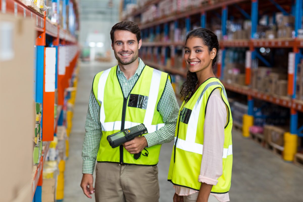 Two smiling warehouse employees at work in an organized and clean space