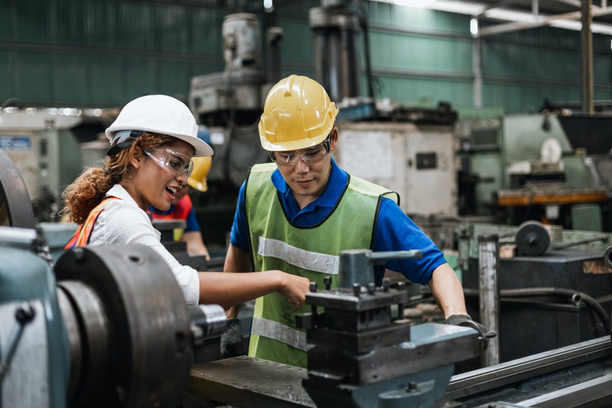 man and woman working in factory with ppe