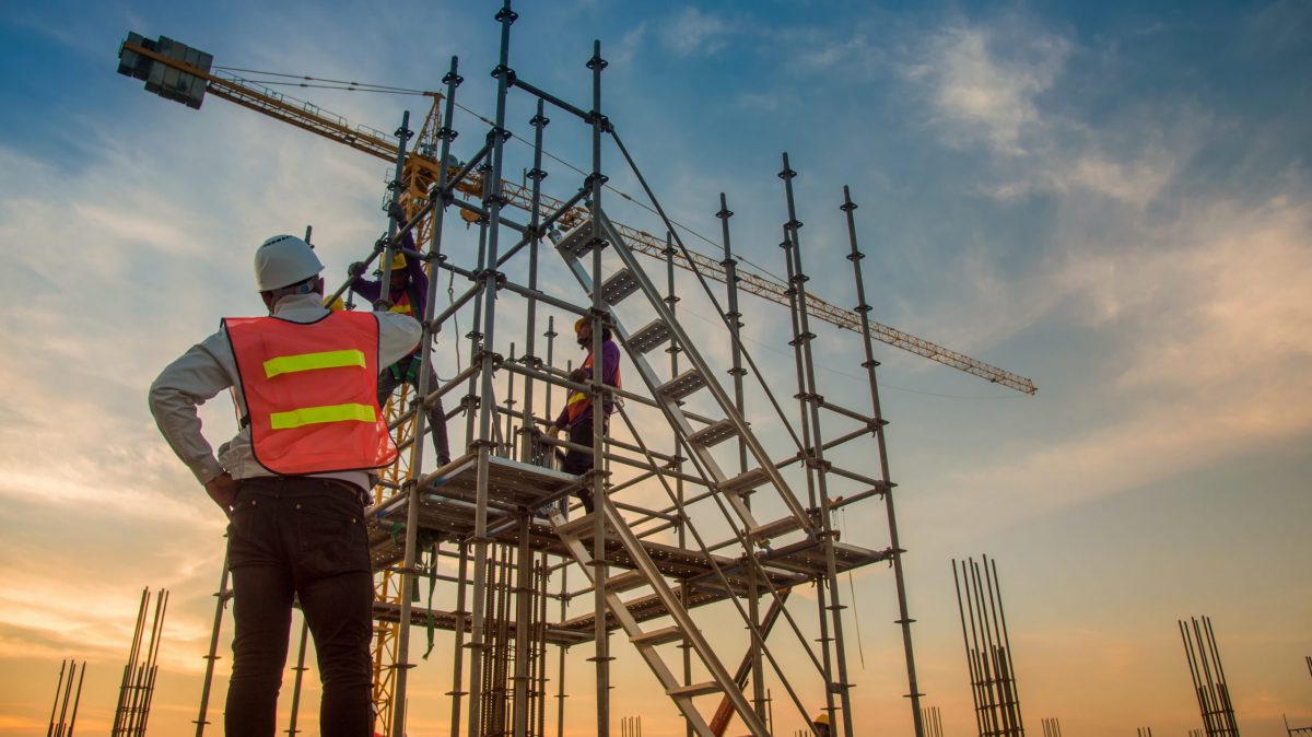 trabajadores que instalan barandillas en los andamios para cumplir los requisitos de la OSHA en materia de protección contra caídas
