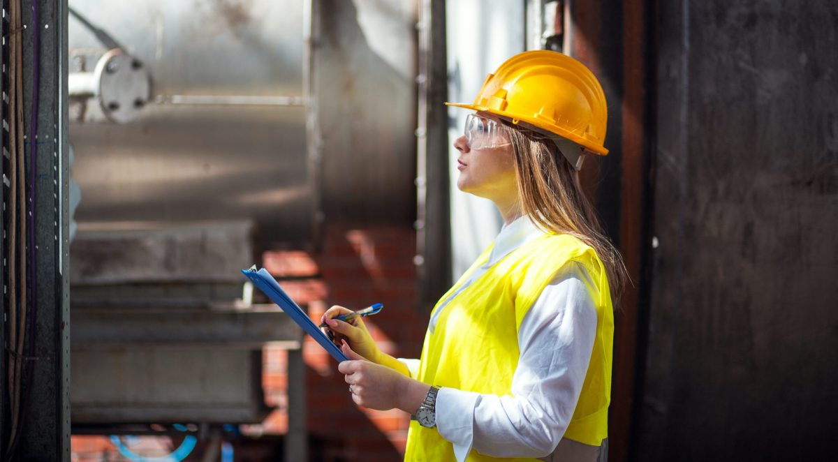 female safety coordinator in hardhat with a clipboard