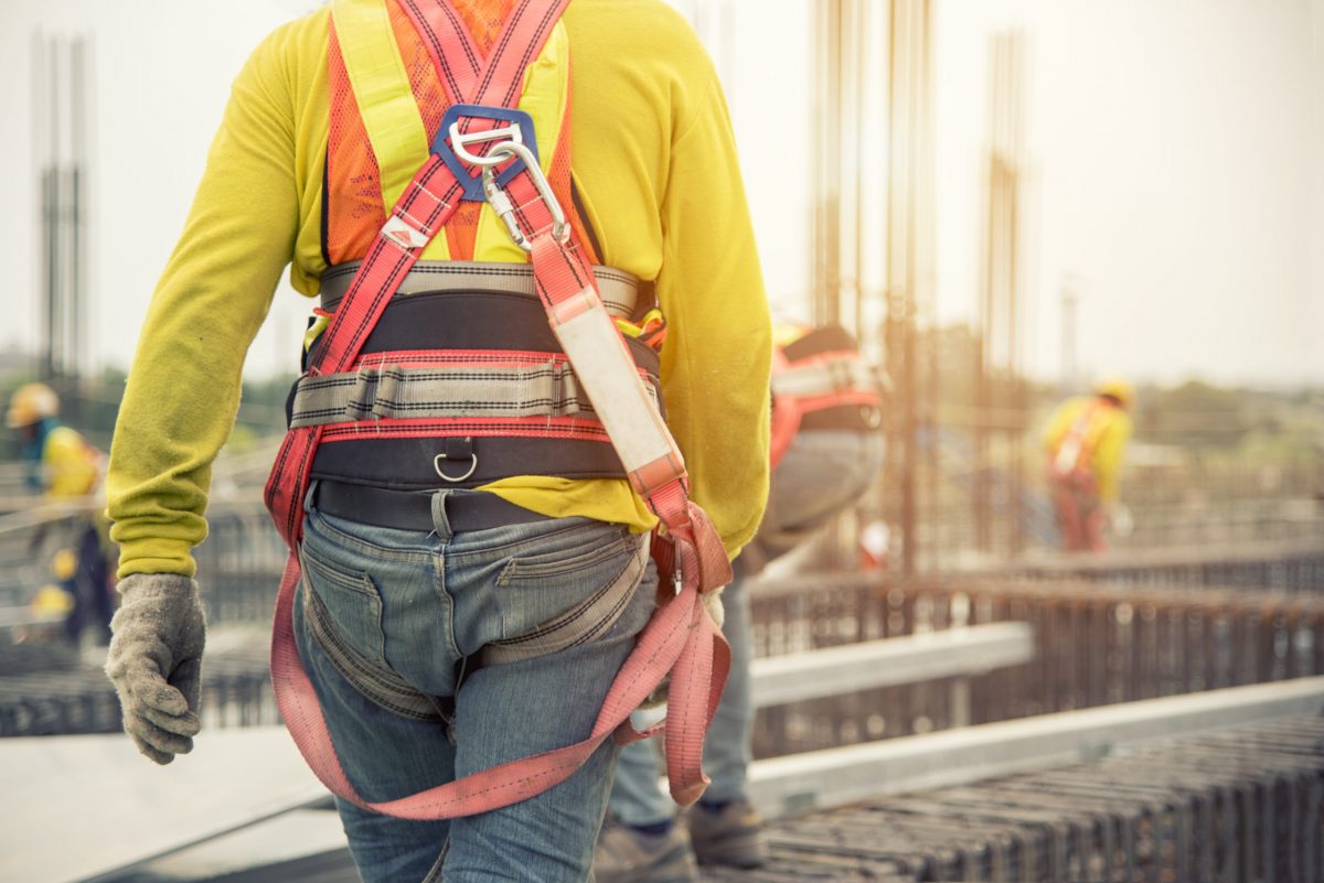 Working At Height Equipment. Fall Arrestor Device For Worker With Hooks For Safety Body Harness On Selective Focus. Worker As A Background.