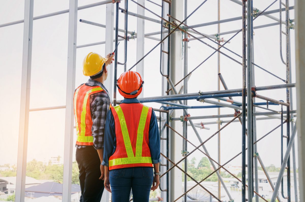 Two workers inspecting a building