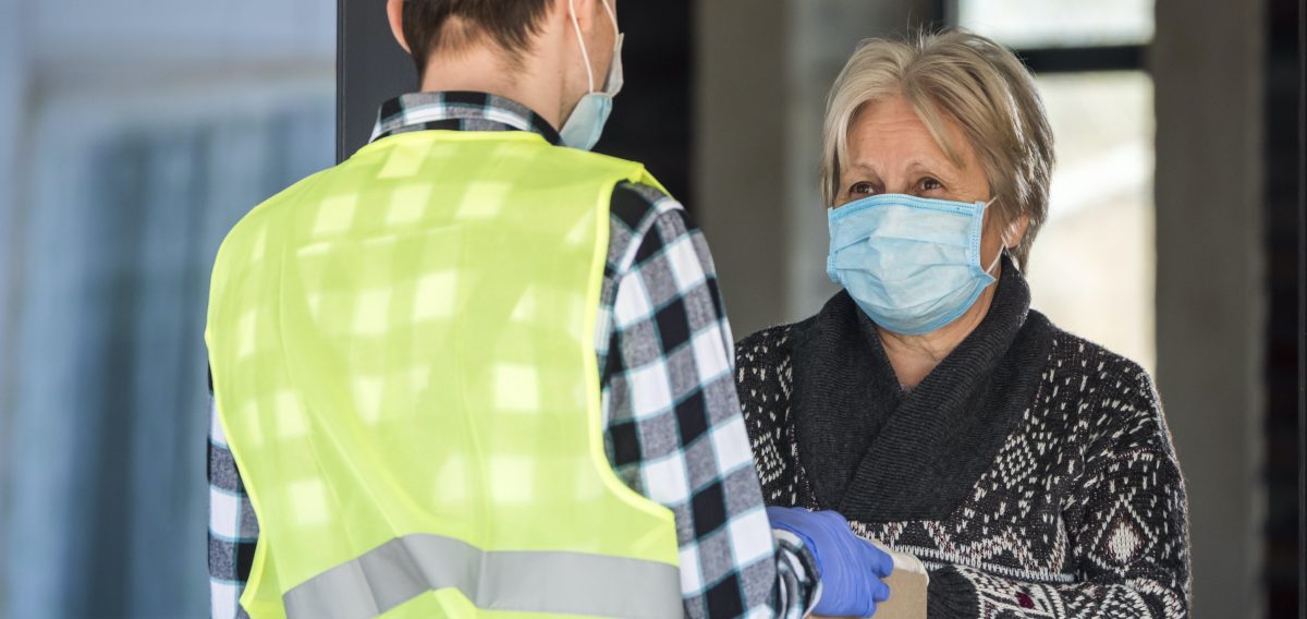 Un cartero entrega un paquete a una anciana durante la epidemia