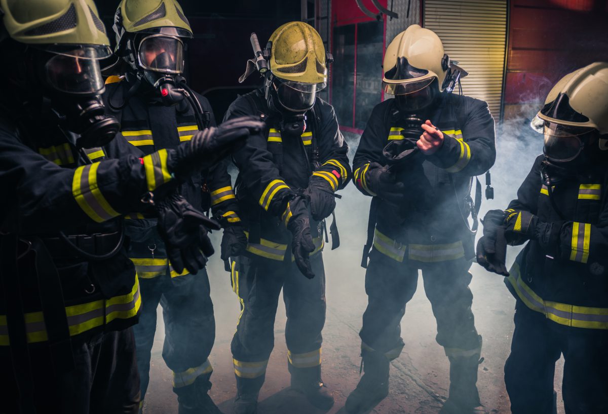 Equipo de bomberos con máscaras de gas y uniforme