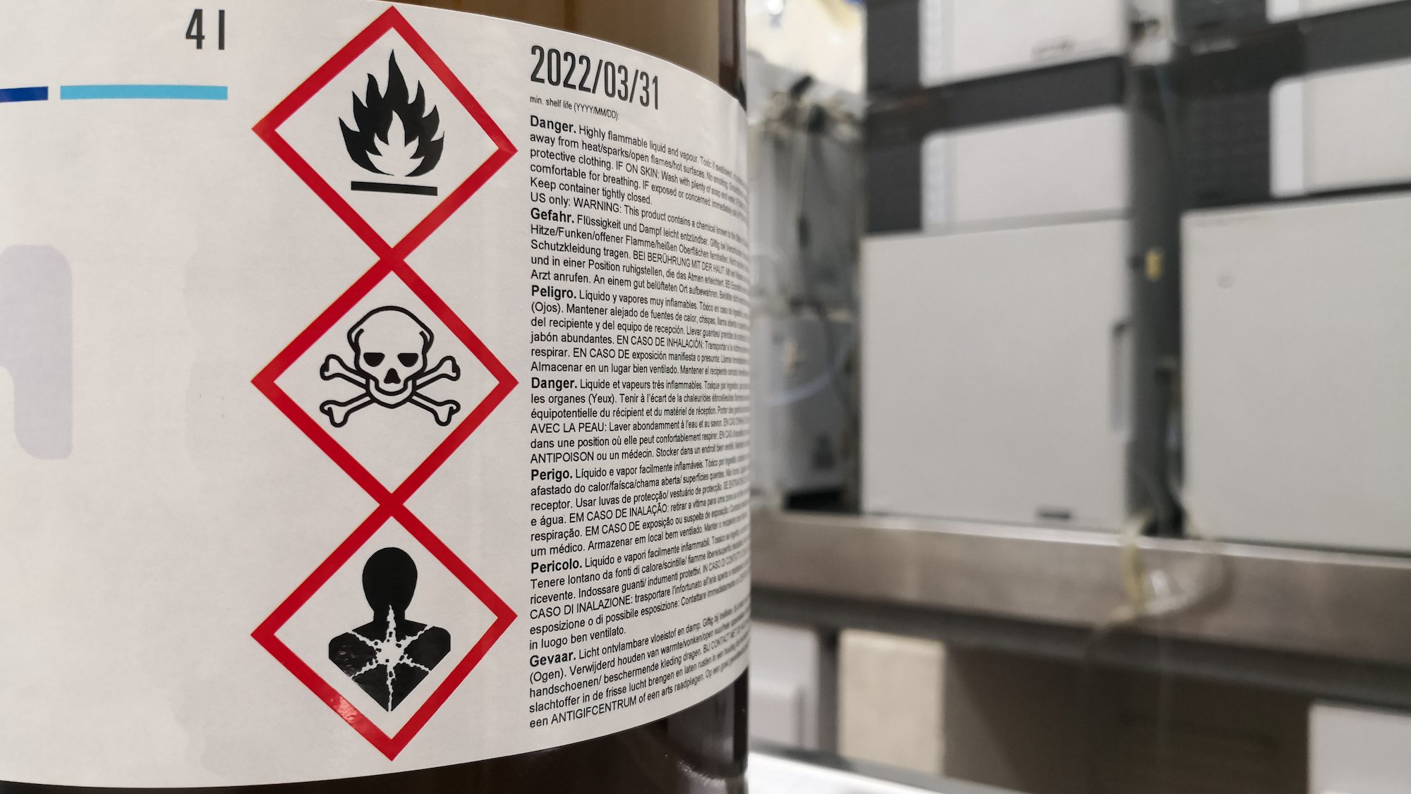 Chemical Substance In A Laboratory. Amber Glass Bottle. Tagged With GHS Symbology With Toxicity, Flammability And Death Warnings. Liquid Chromatography Equipment.